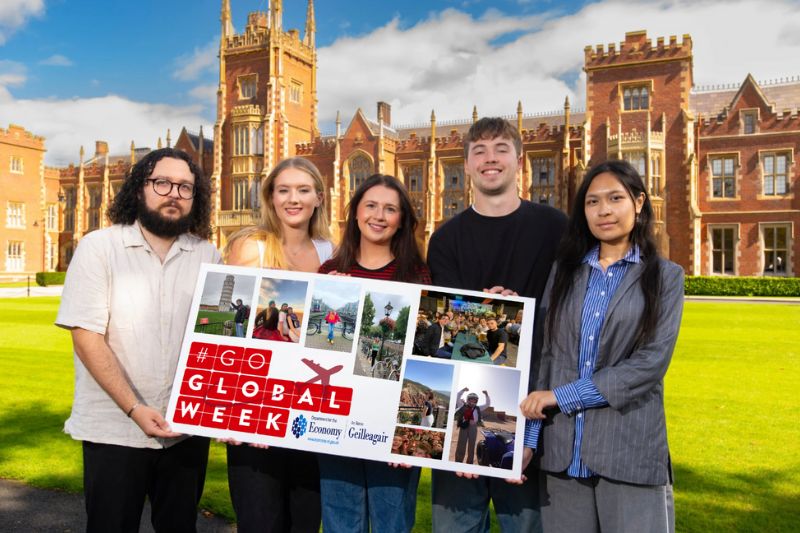 five student ambassadors holding a sign that says go global week in front of Queen's Lanyon building